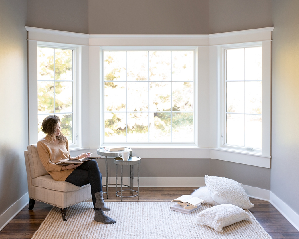 White wood-lifestyle series bay window with woman in corner reading